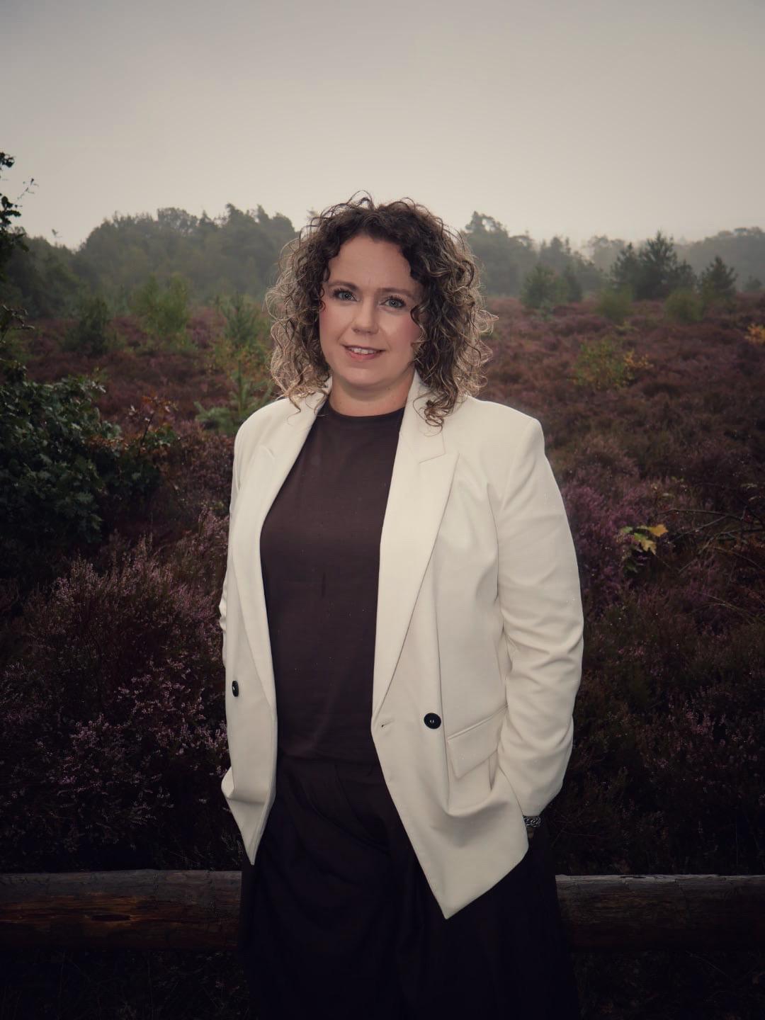 Evelien van der Sar, integratief coach en counselor in Wierden Evelien van der Sar in een crème blazer in de heide bij Wierden